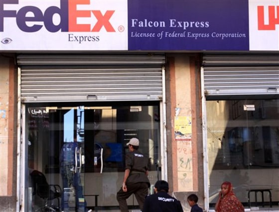 Security men walk into the Falcon Express office, the partner service provider of FedEx in Yemen, on Saturday in San'a.